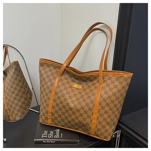 Close-up of the large brown tote bag with geometric print and orange fashion label