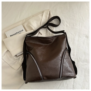 Détail du sac fourre-tout marron foncé avec texture froissée vintage et fermetures éclair