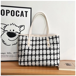 Close-up of black and white striped tweed tote bag showing fabric texture and sturdy straps