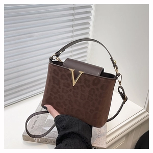 Detalle de bolso bandolera de ante con estampado de leopardo y logo en V dorado