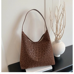 Detail view of stylish leopard print hobo shoulder bag made of textured faux fur fabric