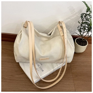 Close-up of large cream leather tote bag on magazine with sleek rectangle logo detail