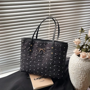Sac fourre-tout noir à pois avec nœuds blancs, boucle dorée et texture matelassée
