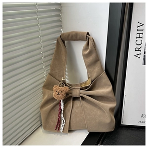 Détail du sac cabas kaki à nœud avec charm ours en peluche et texture plissée