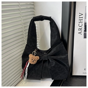 Détail du sac cabas noir en daim avec grand nœud et pendentif ours en peluche
