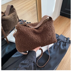 Detail of plush brown teddy fleece shoulder bag with leather strap and metal zipper