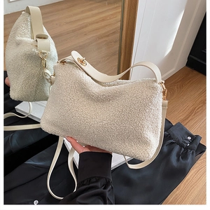 Detail of soft lamb wool crossbody bag with leather strap and gold hardware accents