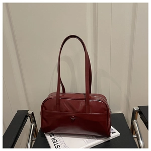 Macro shot of dark red glossy faux leather texture and silver zipper on shoulder bag