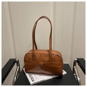 Detailed view of a brown faux leather shoulder bag with metallic buckle and slim straps