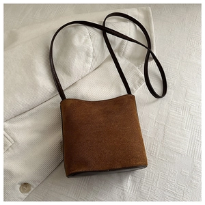 Detailed texture of brown suede leather handbag on corduroy background