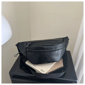 Detail of black wrinkled leather chest bag with zipper and adjustable nylon strap