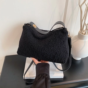 Minimalist black faux shearling shoulder bag with leather trim and gold rotary lock