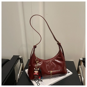 Macro shot of dark red glossy leather texture and metal zipper on shell shoulder bag