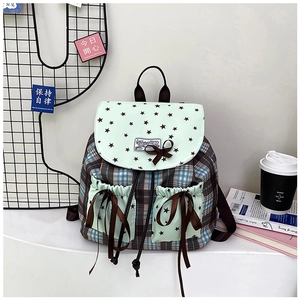Detail of a mini plaid backpack with star pattern flaps and brown ribbon bow