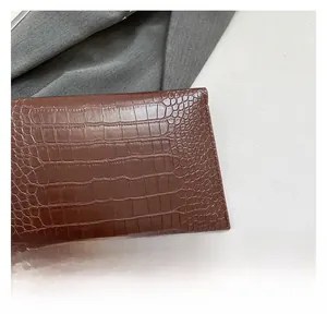 Detail showing high-gloss brown faux leather with crocodile texture and neat stitching