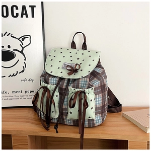Detail of checkered mini backpack with star prints and brown bow accents on wooden desk