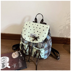 Detail of plaid mint green backpack with star patterns and brown ribbon decoration