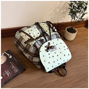 Detail of plaid school backpack with mint green pockets and black star patterns