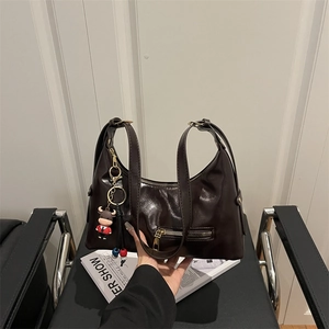 Retro brown oil wax leather shoulder bag with a cute pendant and external zipper pocket