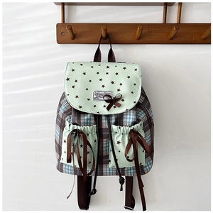 Detail of school backpack with mint green star patterns and brown ribbon bow decoration