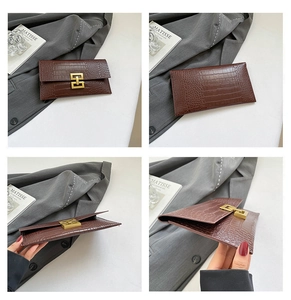 Detail view of brown crocodile texture envelope clutch with gold H-shaped metal buckle