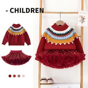 Detail of red knit sweater with colorful wavy patterns and stars on a tutu skirt