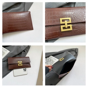 Detailed macro of brown crocodile pattern envelope clutch with gold geometric metal buckle