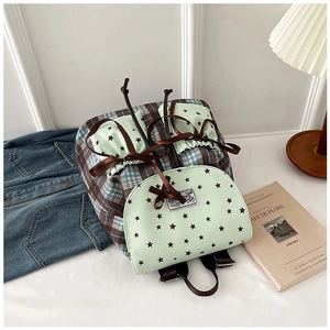 Detail of plaid school backpack with mint green star patterns and ribbon bow decoration