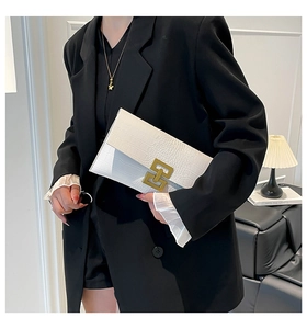Detail view of a white envelope clutch bag with crocodile texture and gold square lock