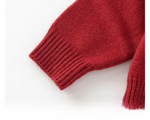 Detailed macro view of the bright red ribbed knit cuffs on the girl's sweater