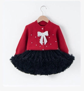 Detail of red knit top with silver sequin bow and black tiered tutu skirt for girls