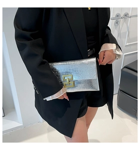 Detailed close-up of silver stone pattern texture and gold buckle on envelope clutch