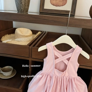 Pink girl's dress with back cross straps and ribbed knit bodice on wooden display