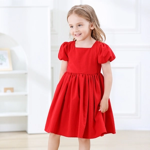 Détail de robe rouge pour fille avec manches bouffantes, col carré et plis