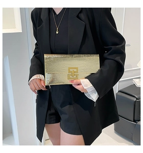 Detail of a gold faux leather envelope clutch featuring embossed stone texture and metal clasp