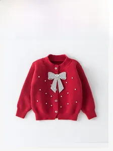 Detail of red knit cardigan for girls with sequined silver bow and rhinestone accents