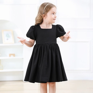 Détail d'une robe noire pour fille avec col carré élégant et manches bouffantes