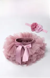 Detail of pink tutu skirt with satin bow and matching floral headband set