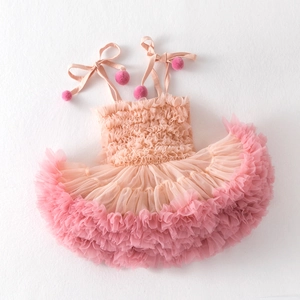 Detailed view of layered pink mesh tutu dress with ruffle hem and pom-pom straps