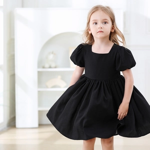 Détail d'une robe noire pour fille à col carré avec manches bouffantes et coton texturé