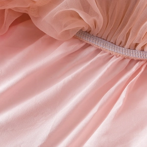 Detail of pink tutu dress showing tulle layers, elastic waistband, and satin lining texture