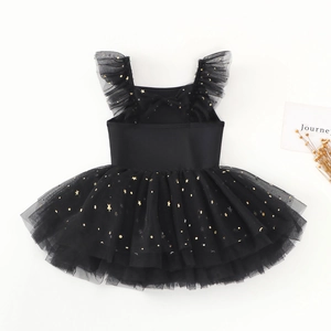Detail of girls ballet tutu dress with golden star and moon prints on black mesh layers