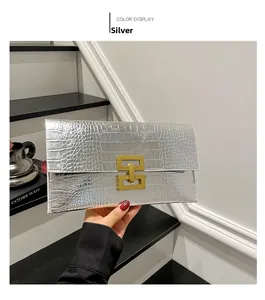 Detailed view of silver crocodile textured clutch bag with a golden geometric metal lock