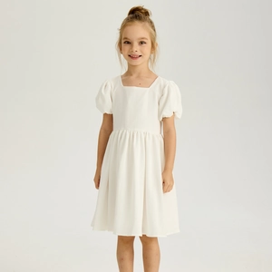 Détail d'une robe fille à col carré et manches bouffantes en tissu coton et lin