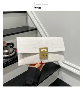 Detail of white stone pattern envelope clutch with golden geometric metal buckle