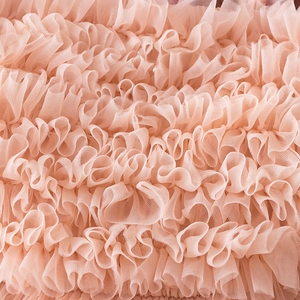 Detail of multi-layered peach pink tulle fabric with delicate mesh ruffles for tutu dress
