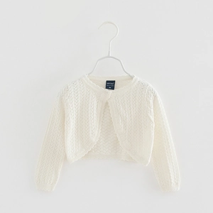 Close-up of white knitted baby cardigan with delicate lace edges and openwork texture