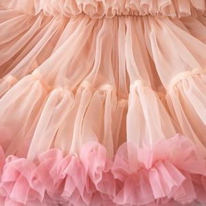 Close-up of layered tulle ruffles on a tiered pink gradient princess dress