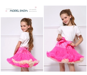 Detail of pink tutu skirt with tiered mesh layers, lace edges, and a silk bow at the waist