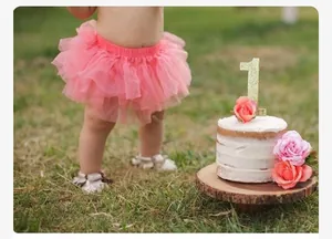 Detail of coral pink baby tutu skirt with layered mesh for first birthday party